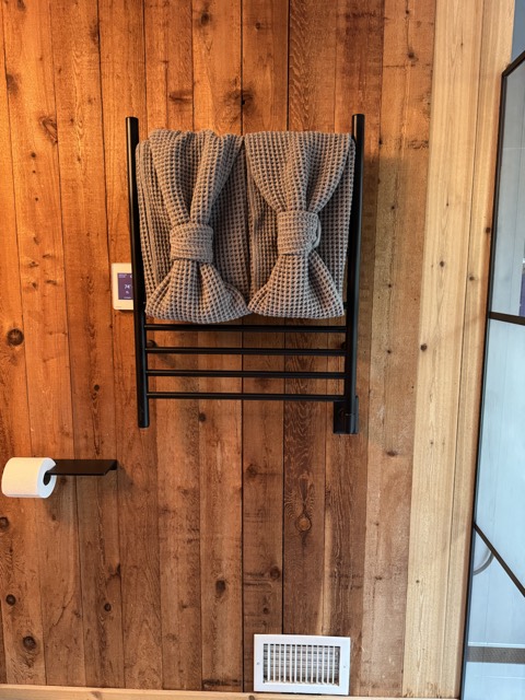 Folded towels on a towel rack in a cleaned bathroom