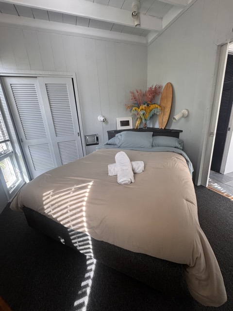 Bedroom with fresh bedding and folded towels for guests
