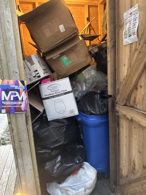 Storage shed full of boxes and trash before a cleanout